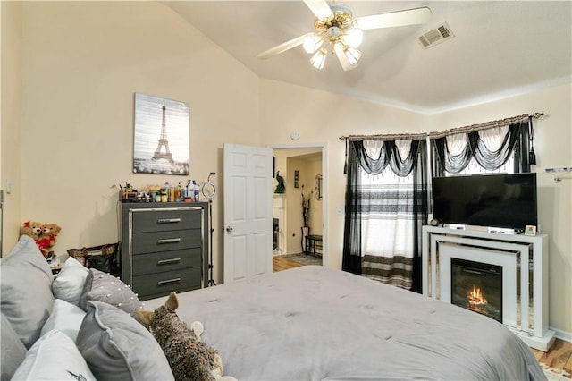 bedroom featuring ceiling fan, wood-type flooring, and vaulted ceiling