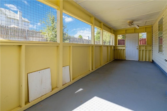 unfurnished sunroom featuring ceiling fan