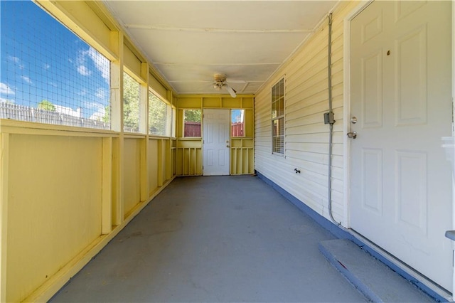 unfurnished sunroom featuring ceiling fan