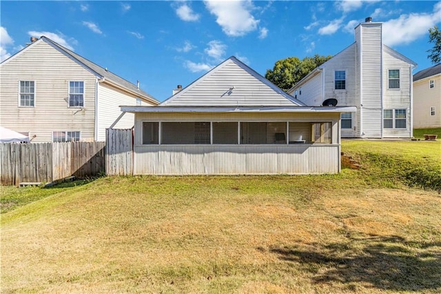 back of house featuring a sunroom and a lawn