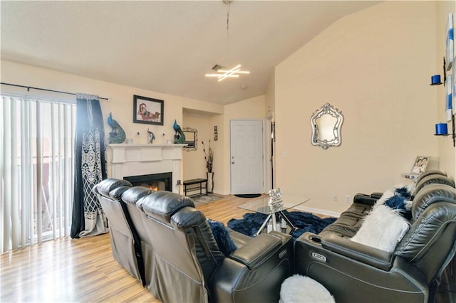 living room featuring lofted ceiling and light hardwood / wood-style floors