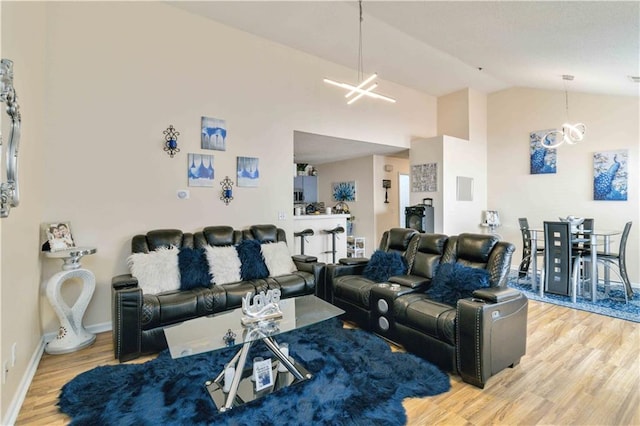 living room with high vaulted ceiling, wood-type flooring, and a chandelier