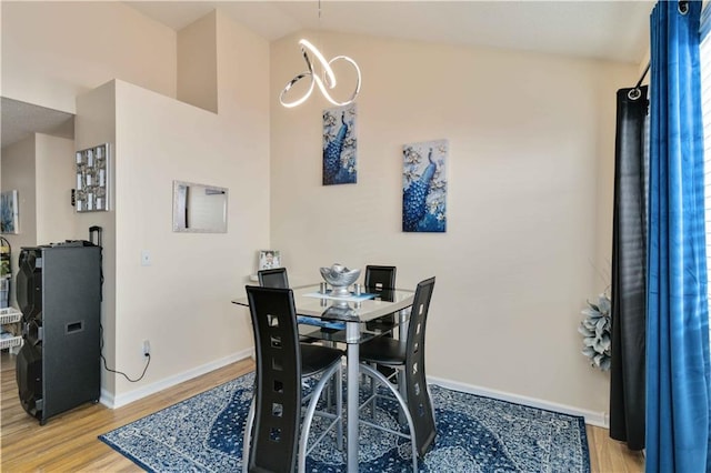 dining space featuring vaulted ceiling and light hardwood / wood-style flooring