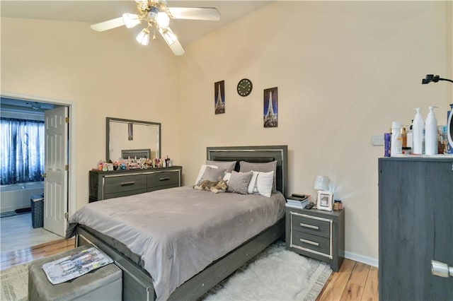 bedroom featuring lofted ceiling, connected bathroom, light wood-type flooring, and ceiling fan