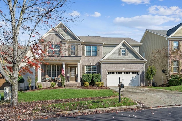 view of front of property with a front yard, a balcony, a garage, and covered porch