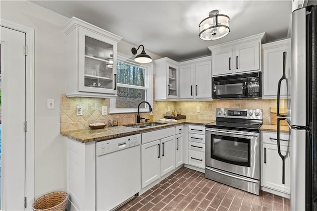 kitchen featuring tasteful backsplash, appliances with stainless steel finishes, white cabinets, and a sink