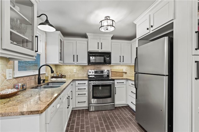 kitchen featuring backsplash, appliances with stainless steel finishes, glass insert cabinets, white cabinets, and a sink