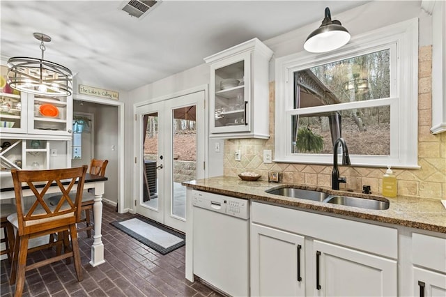 kitchen with french doors, visible vents, backsplash, white dishwasher, and a sink