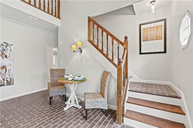 staircase with brick floor and baseboards