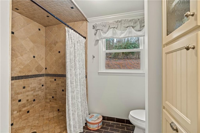 full bathroom with a stall shower, baseboards, crown molding, and toilet