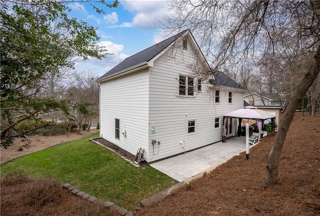 rear view of property featuring a gazebo, a patio, and a lawn