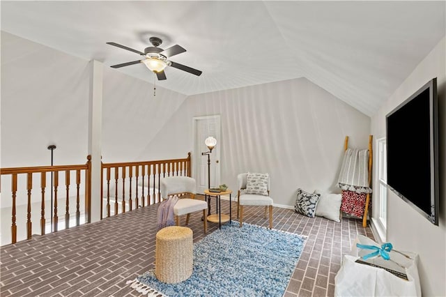 sitting room with brick floor, vaulted ceiling, and ceiling fan