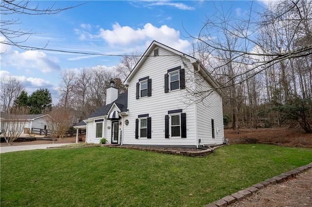 traditional-style house with a chimney and a front yard