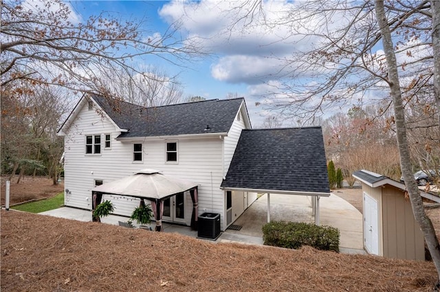 exterior space with a shingled roof, a gazebo, and central air condition unit