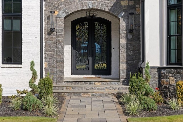 doorway to property with french doors, brick siding, and stone siding