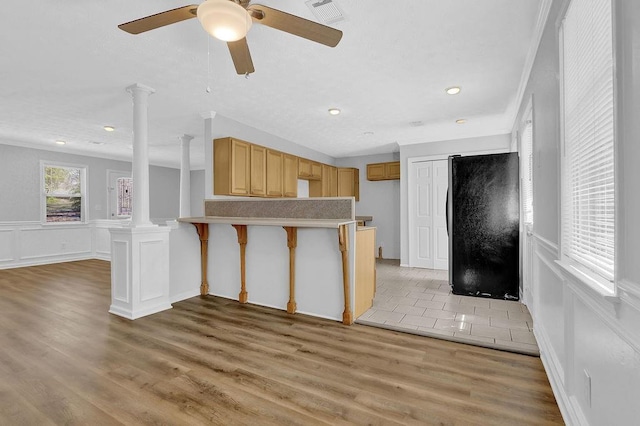 3618 Mansfield Ln, Snellville, GA 30039 - kitchen with decorative columns, freestanding refrigerator, a peninsula, light wood-style flooring, and visible vents