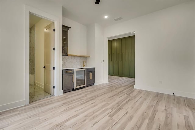 4265 Haynes Cir, Snellville, GA 30039 - kitchen with wine cooler, sink, decorative backsplash, and light wood-type flooring