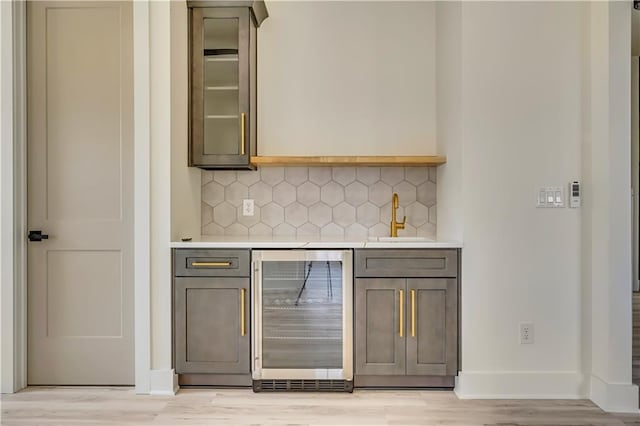 4265 Haynes Cir, Snellville, GA 30039 - bar featuring sink, beverage cooler, backsplash, and light wood-type flooring