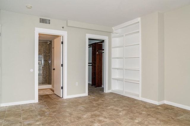 unfurnished bedroom featuring a closet, visible vents, connected bathroom, and baseboards