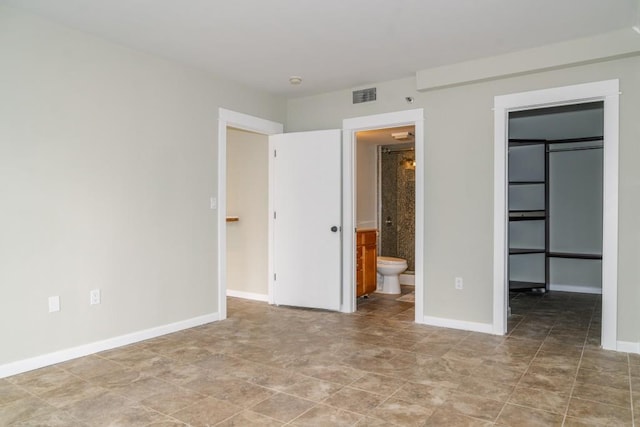 unfurnished bedroom with visible vents, a spacious closet, and baseboards