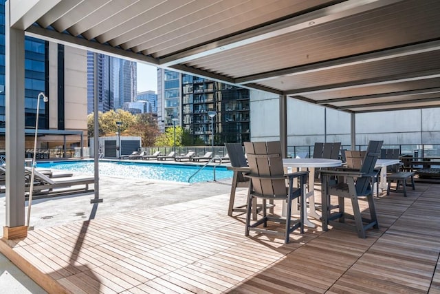 community pool featuring a view of city, a patio, and fence