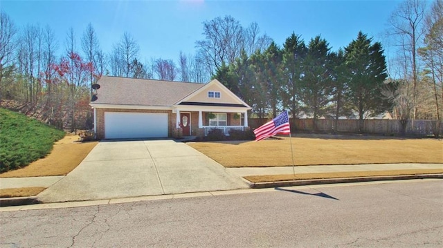 view of front of house with a garage, concrete driveway, fence, a front yard, and brick siding