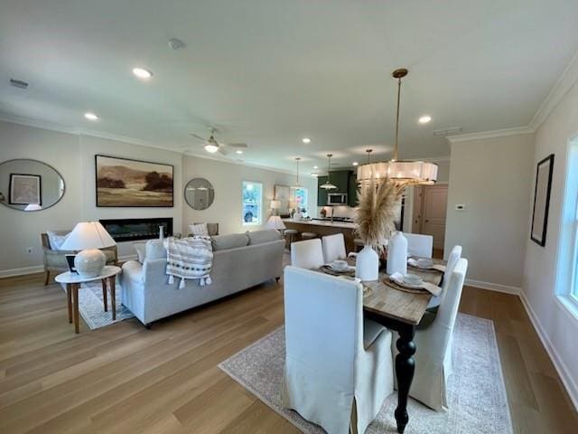 120 Winsome Way, Woodstock, GA 30188 - dining room featuring ornamental molding, a ceiling fan, light wood-style flooring, recessed lighting, and a glass covered fireplace