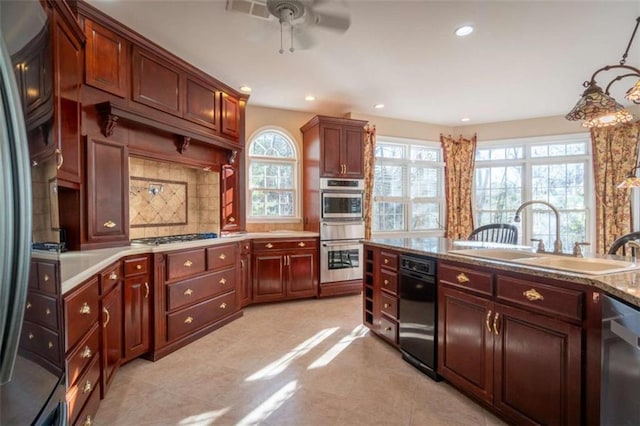 kitchen featuring tasteful backsplash, sink, stainless steel appliances, and decorative light fixtures