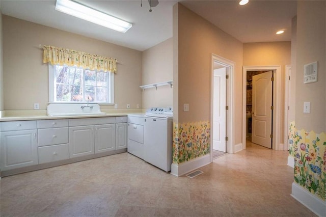 laundry room with cabinets, washing machine and dryer, and sink