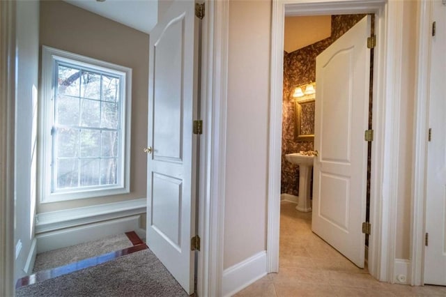 hall featuring light tile patterned floors and sink