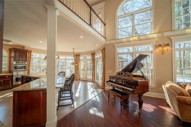 misc room featuring french doors, a towering ceiling, ornate columns, sink, and dark hardwood / wood-style floors