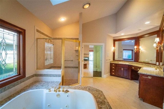 bathroom with plus walk in shower, vanity, lofted ceiling with skylight, and a healthy amount of sunlight