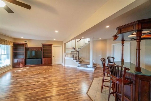 living room featuring ceiling fan and light hardwood / wood-style flooring