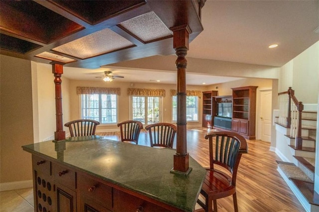 dining area featuring ceiling fan and coffered ceiling