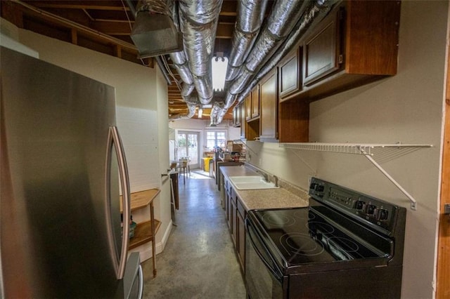 kitchen with sink, stainless steel refrigerator, and black / electric stove