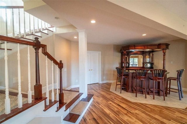 dining space with light hardwood / wood-style floors and indoor bar