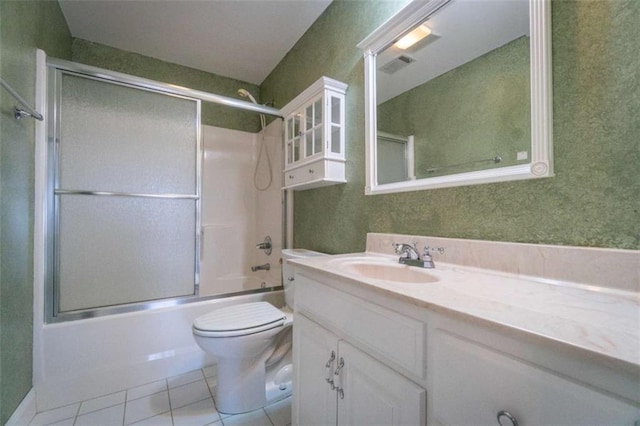 full bathroom with tile patterned floors, vanity, bath / shower combo with glass door, and toilet