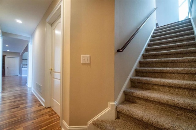 stairs featuring hardwood / wood-style floors