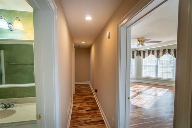 hall with hardwood / wood-style flooring and sink