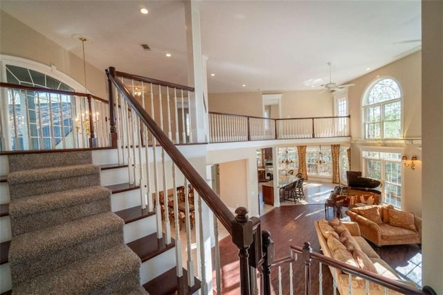 staircase featuring ceiling fan with notable chandelier