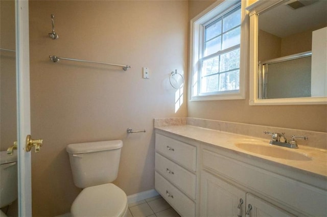 bathroom featuring tile patterned floors, vanity, toilet, and a shower with shower door