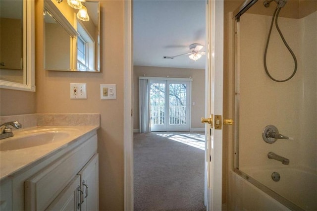 bathroom with combined bath / shower with glass door, vanity, and ceiling fan