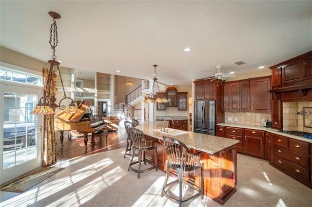 kitchen with pendant lighting, a kitchen island with sink, sink, a breakfast bar area, and stainless steel appliances