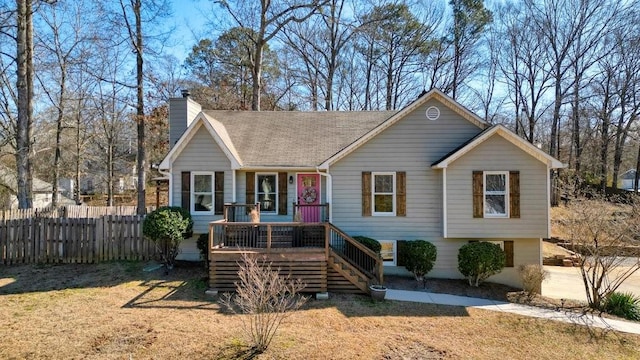 view of front of home with a front yard, fence, a chimney, and stairs