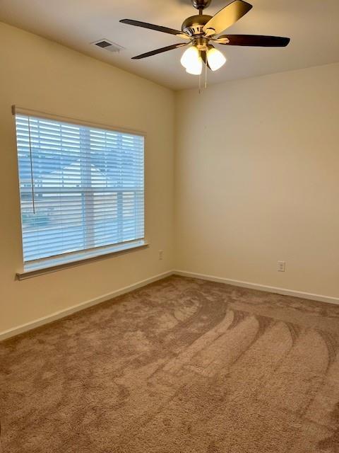 spare room featuring carpet flooring and ceiling fan