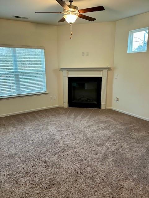 unfurnished living room with ceiling fan and carpet floors