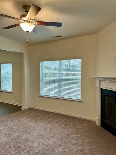 unfurnished living room featuring carpet flooring and ceiling fan