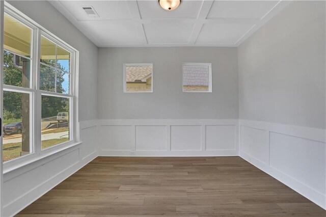 spare room featuring coffered ceiling and hardwood / wood-style floors