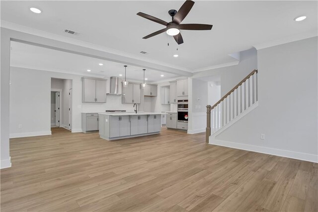 unfurnished living room with light hardwood / wood-style flooring, ceiling fan, crown molding, and sink