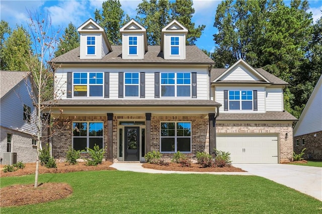 view of front of property with a garage, covered porch, and a front yard